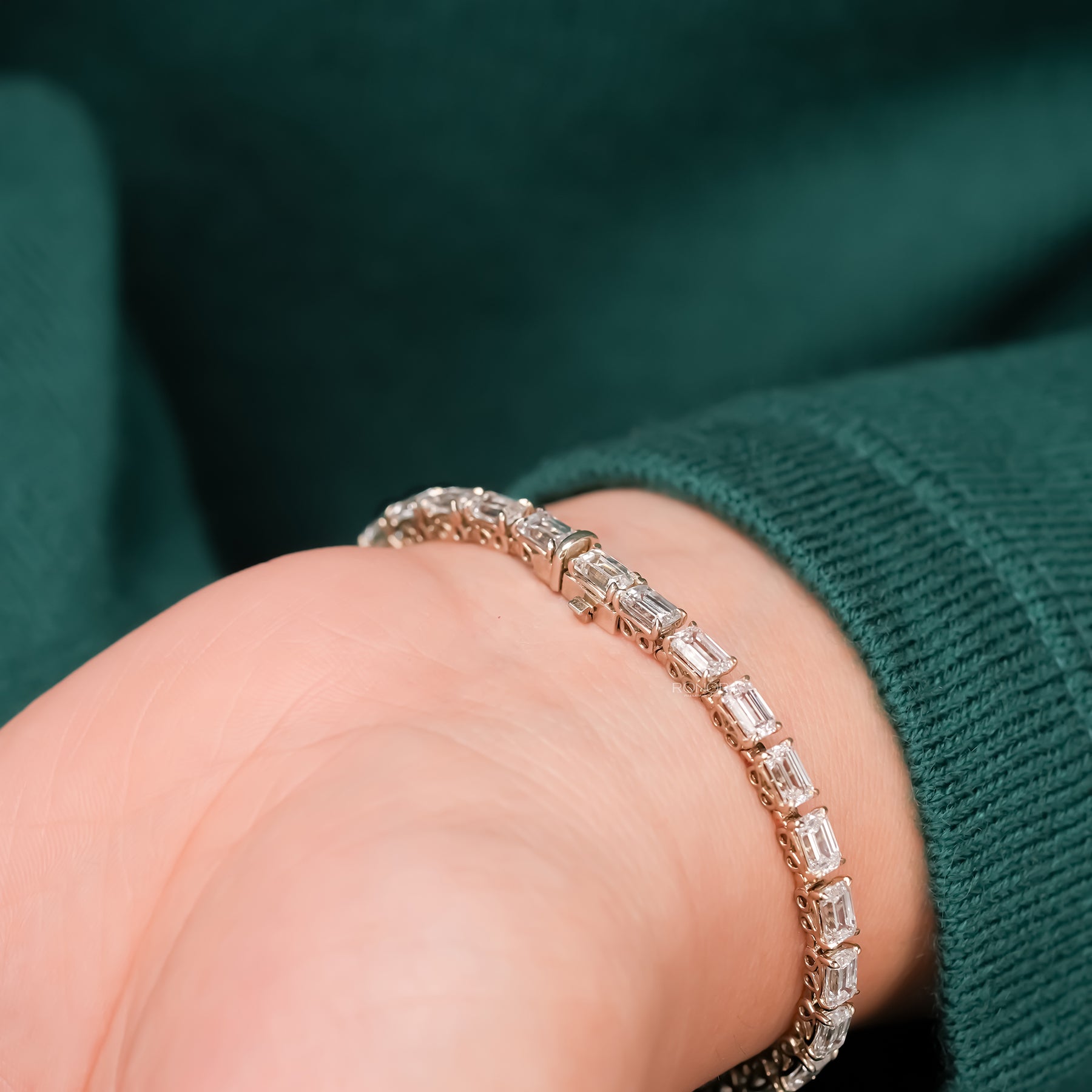 Close-up emerald lab grown diamond tennis bracelet on wrist