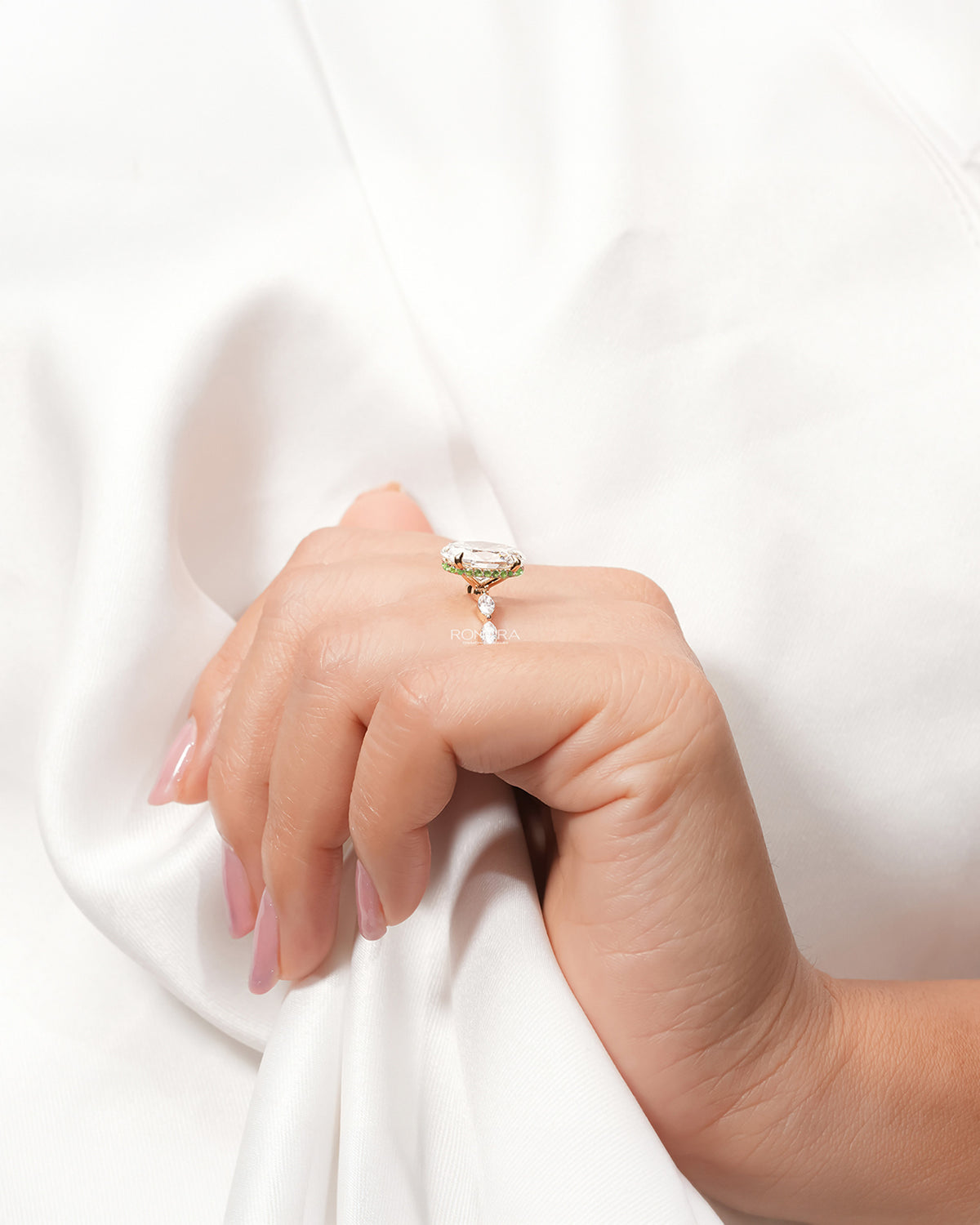 Oval marquise lab grown diamond three-stone ring worn with white silk