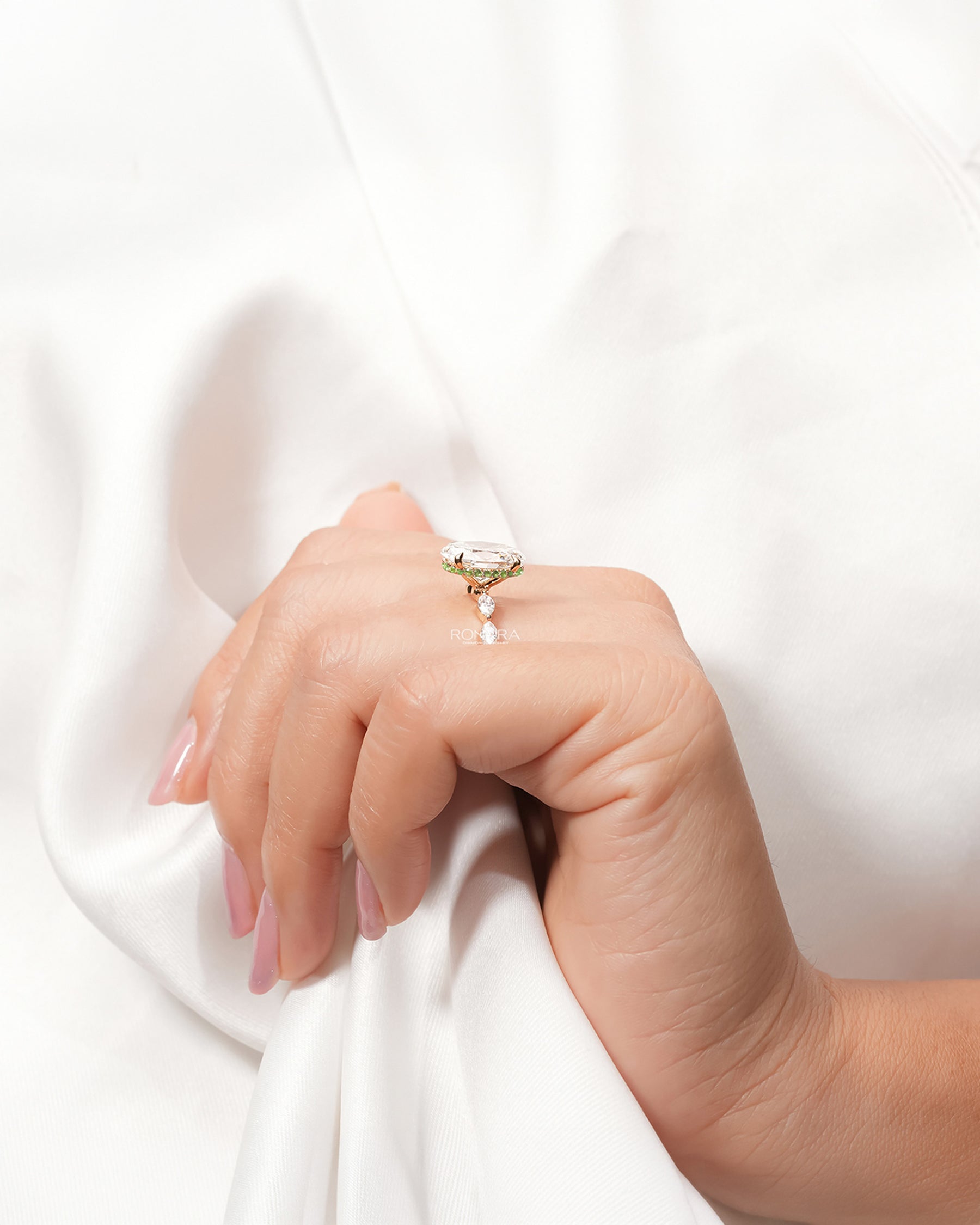 Oval marquise lab grown diamond three-stone ring worn with white silk