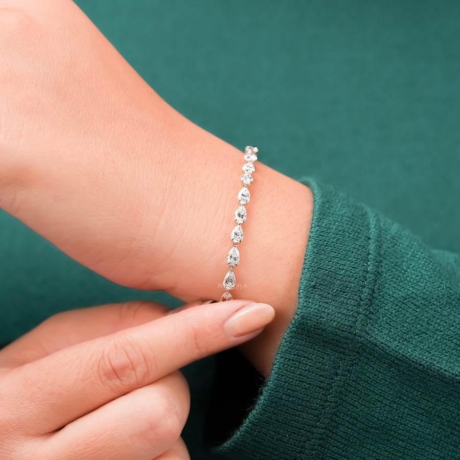 Pear lab grown diamond tennis bracelet being adjusted on wrist