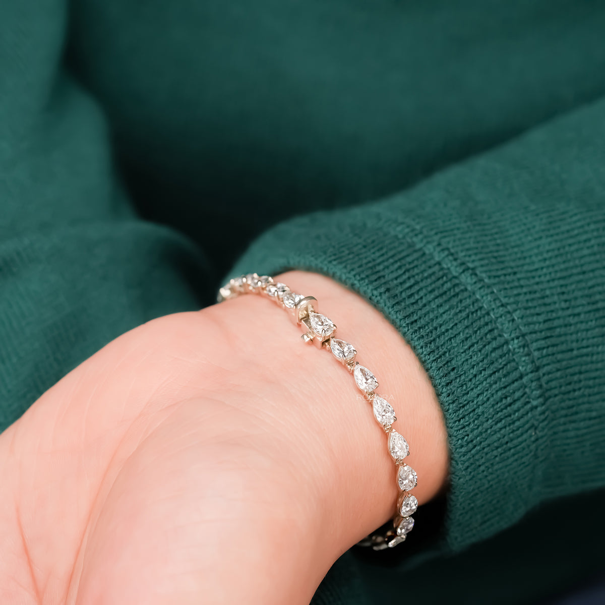Close-up pear lab grown diamond tennis bracelet on wrist