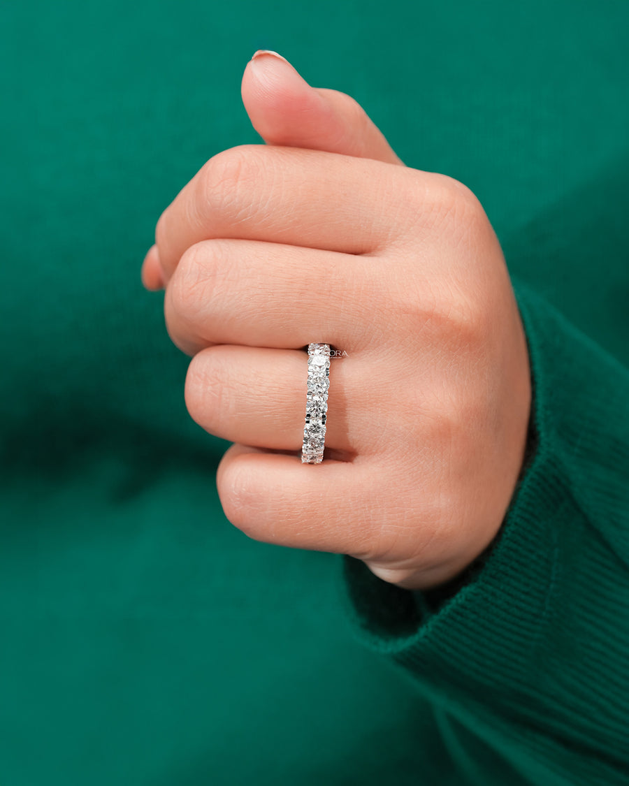 round lab grown diamond eternity band worn on hand in white gold