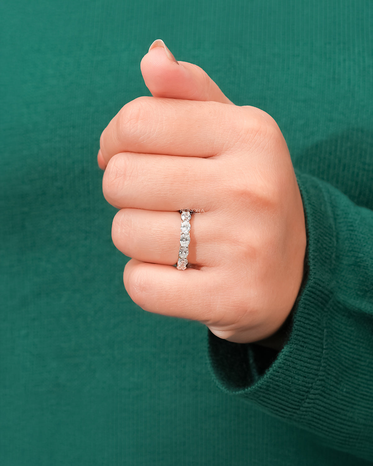 oval lab grown diamond eternity band worn on hand in white gold