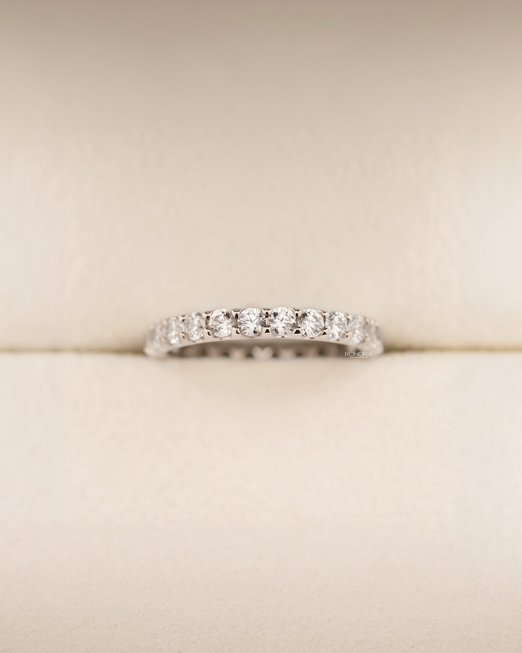 Angled view of round lab grown diamond eternity band showing shared-prong eternity setting
