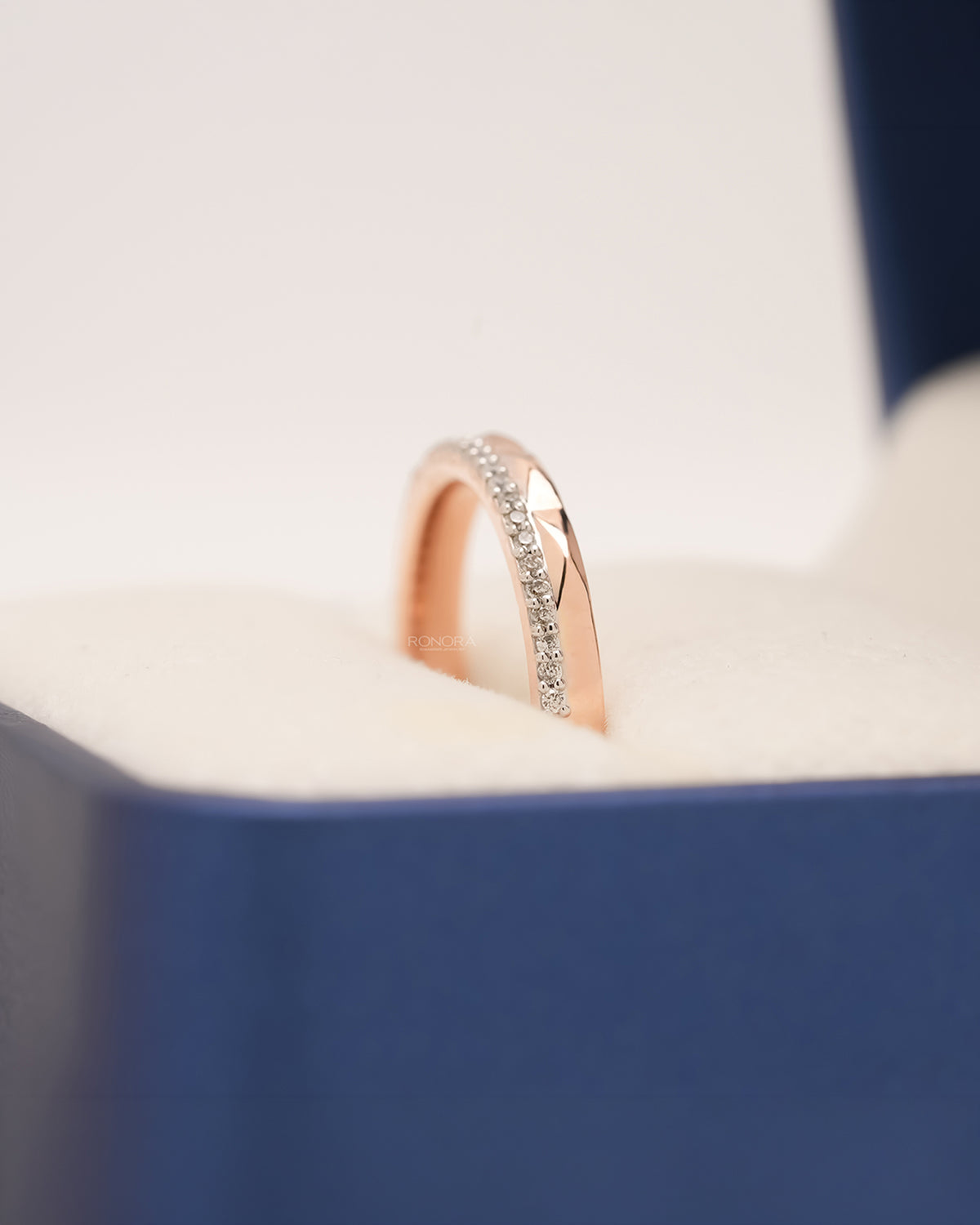 Side profile of rose gold split pavé band showing diamond row