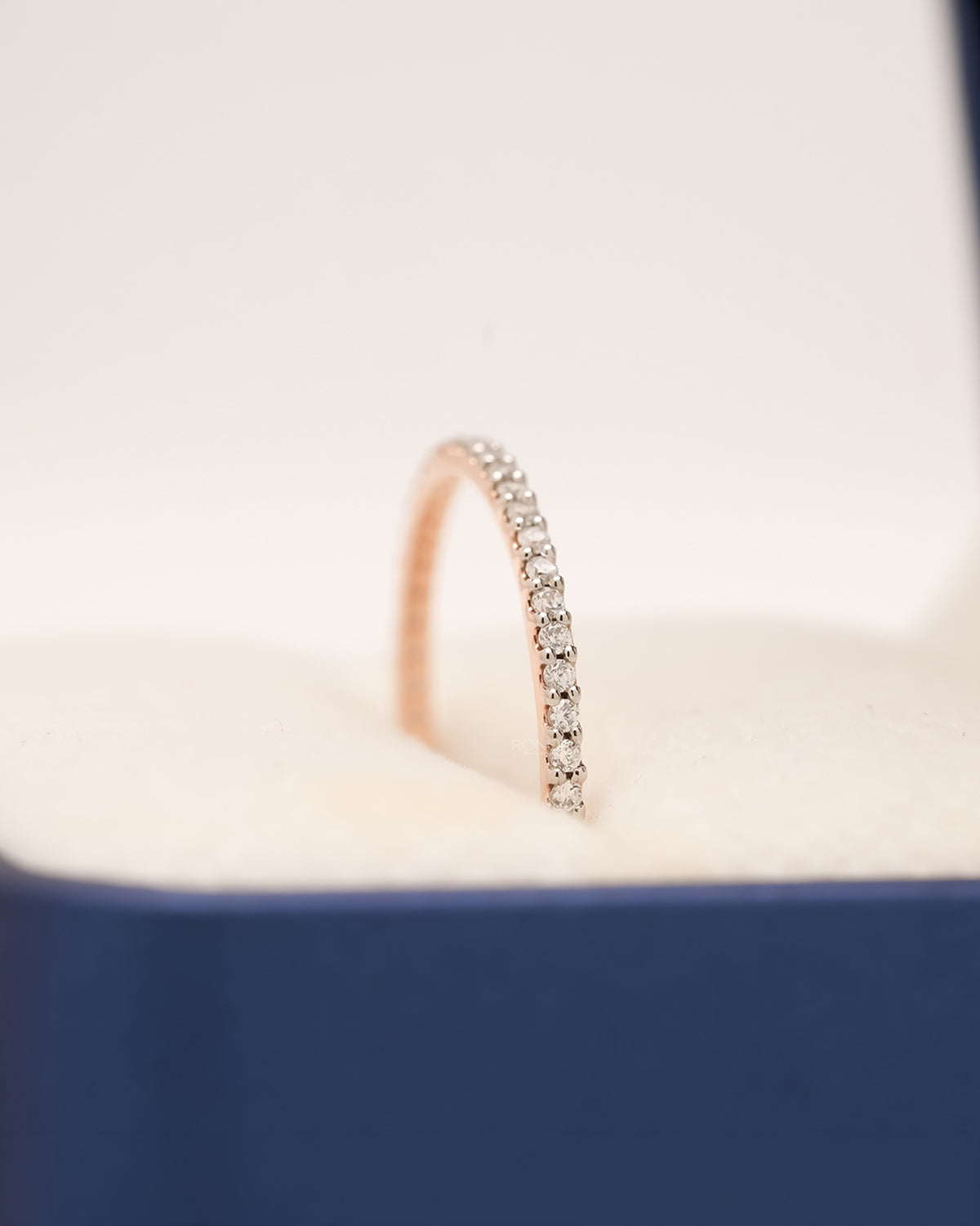 Side profile of rose gold pavé eternity band showing diamond row