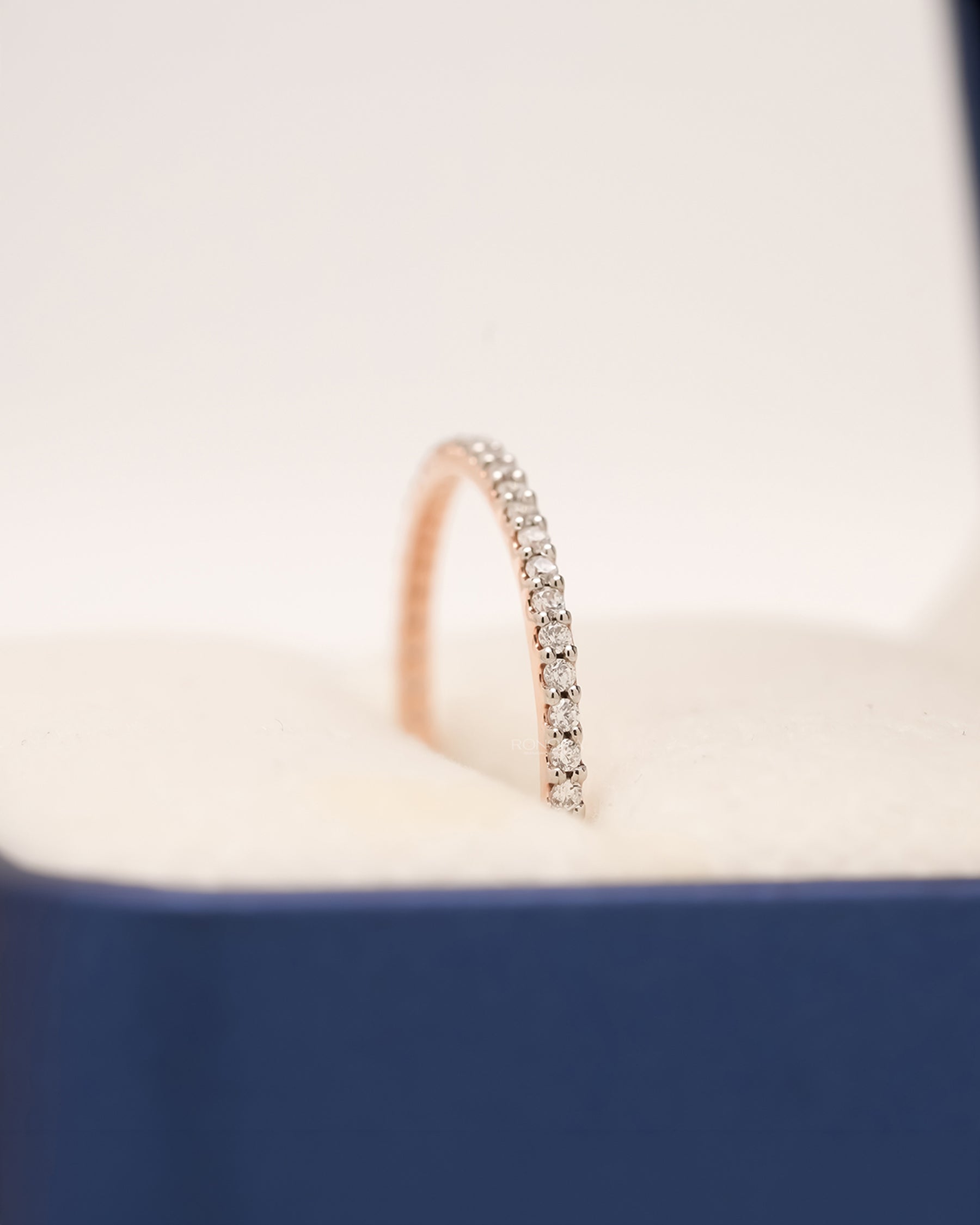 Side profile of rose gold pavé eternity band showing diamond row