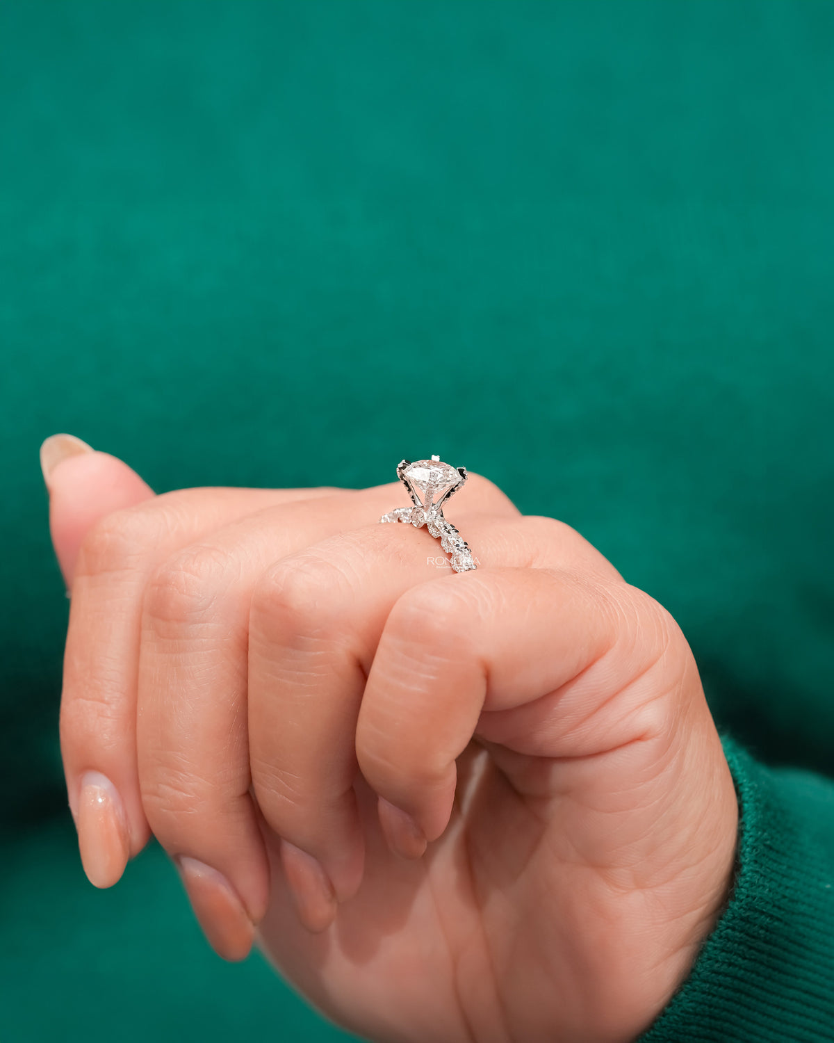 round lab grown diamond side-stone ring worn with luxury styling in white gold