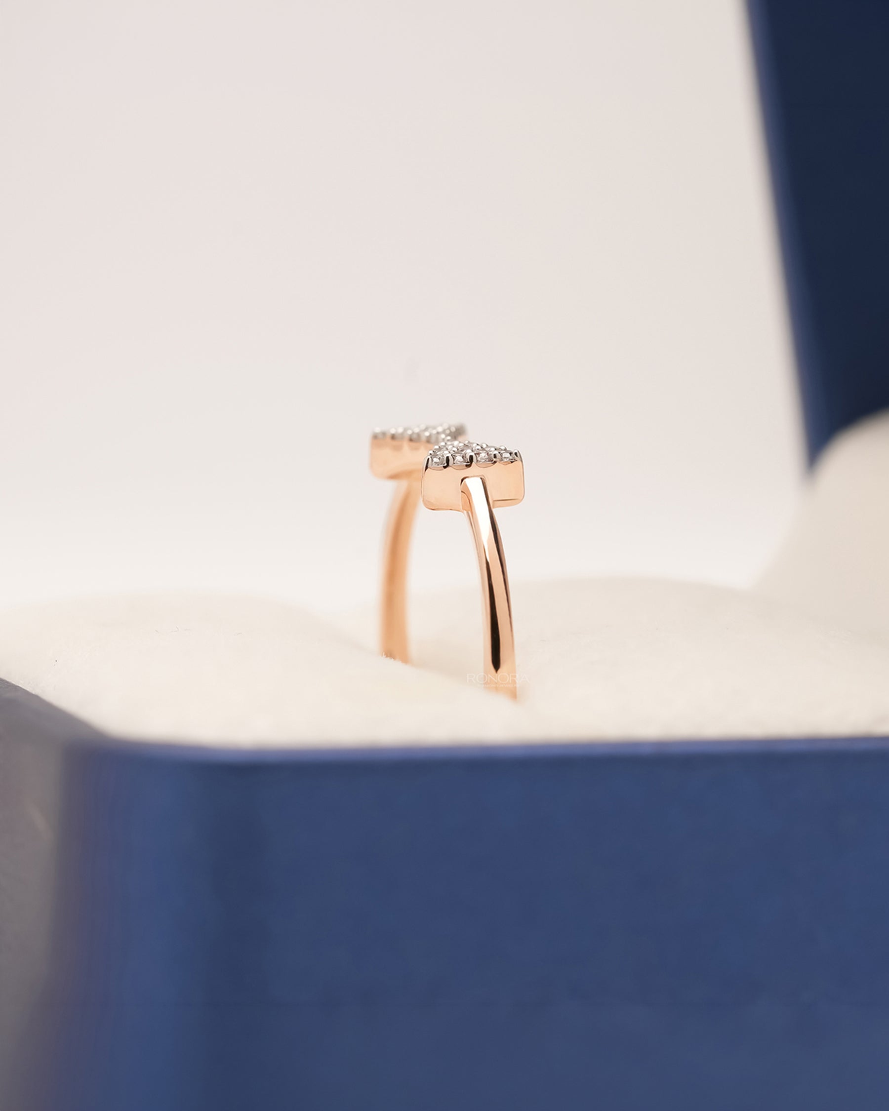 Side profile of rose gold pavé bow ring showing diamond cluster detail