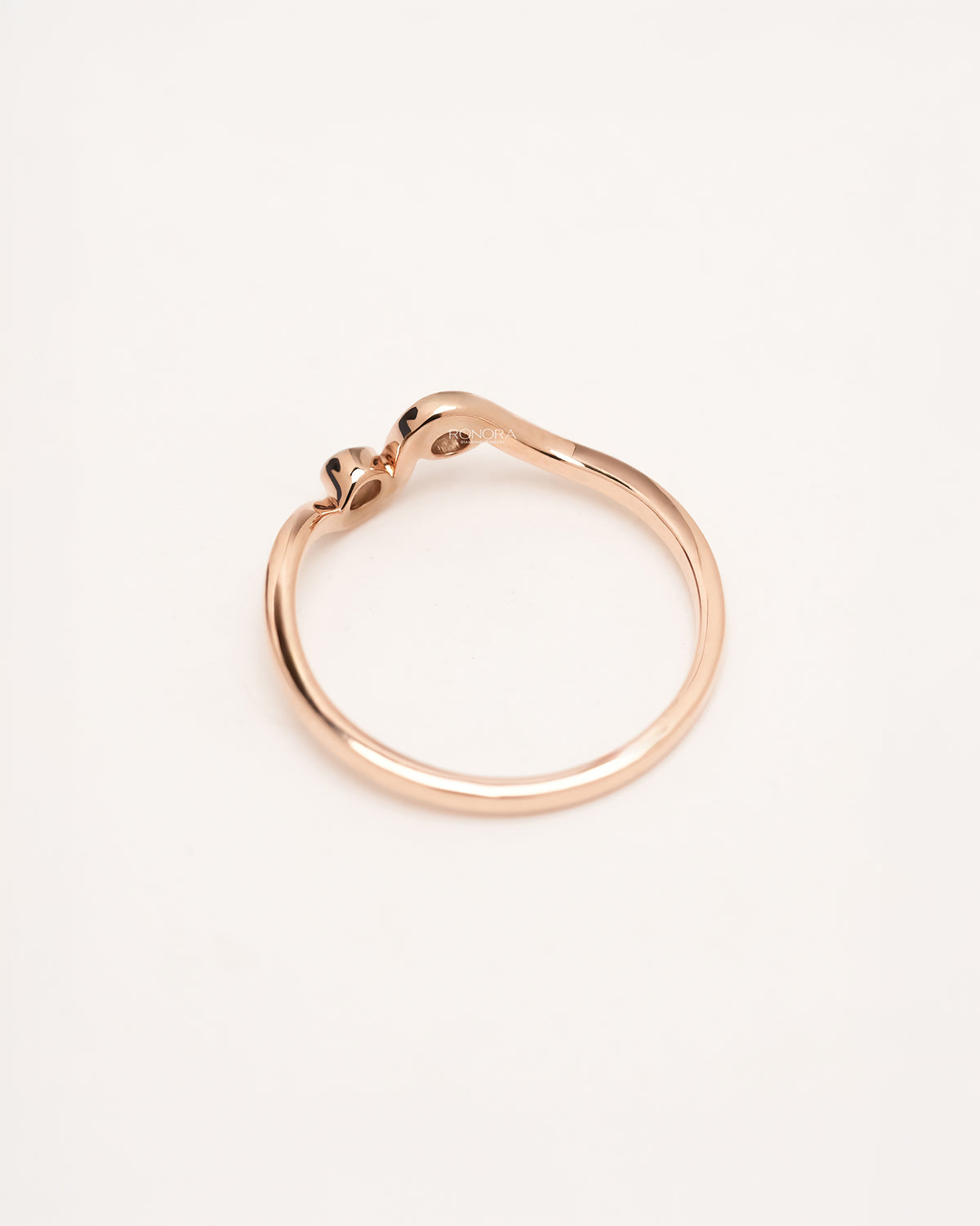 Back view of rose gold two-stone wave ring showing bezel settings and slim band