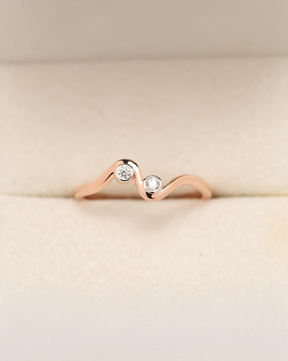 Round bezel-set lab grown diamond wave ring in rose gold with curved band