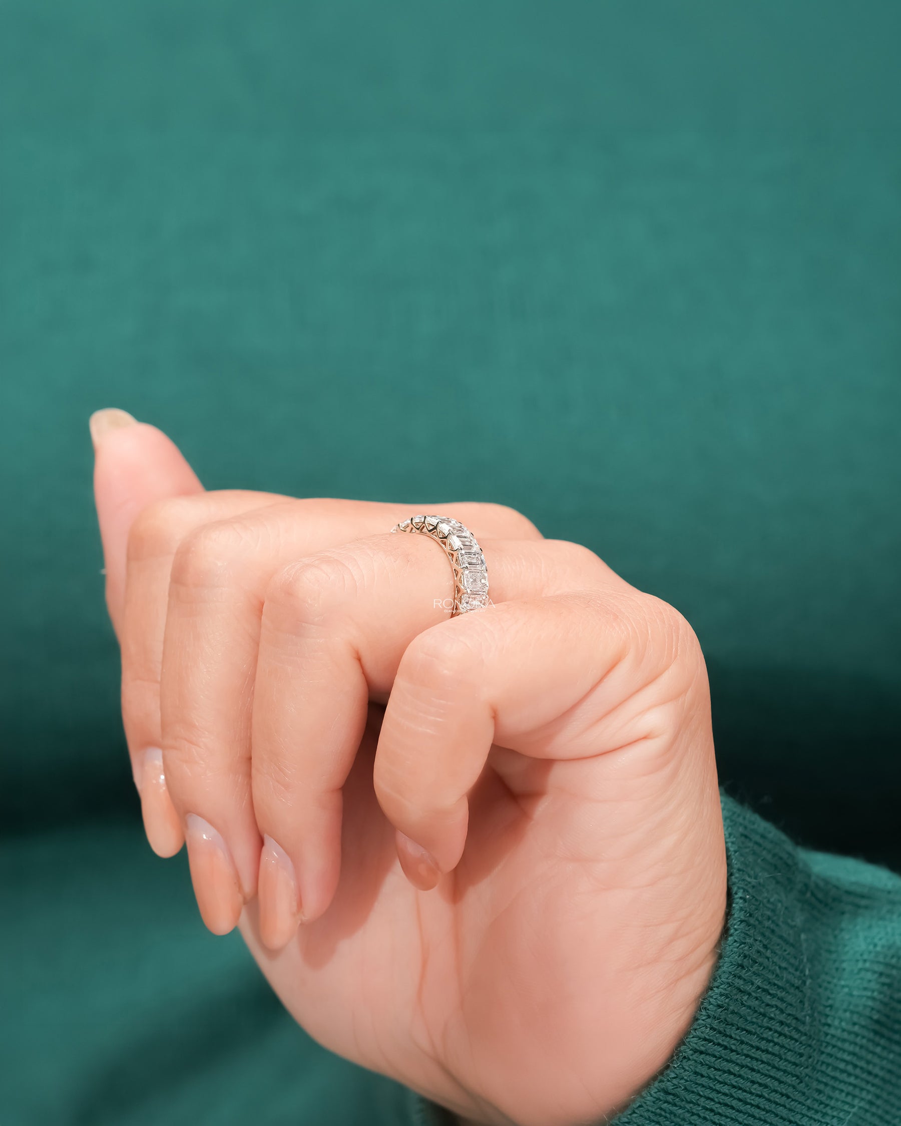 emerald lab grown diamond eternity band worn with luxury styling in white gold