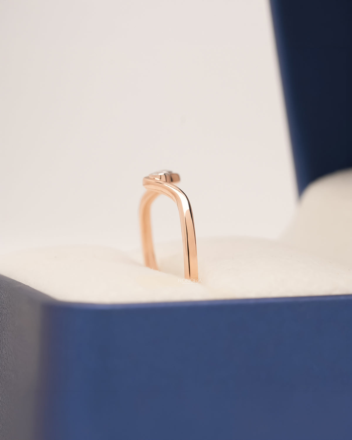 Side profile of rose gold lab grown diamond wave ring in Ronora ring box