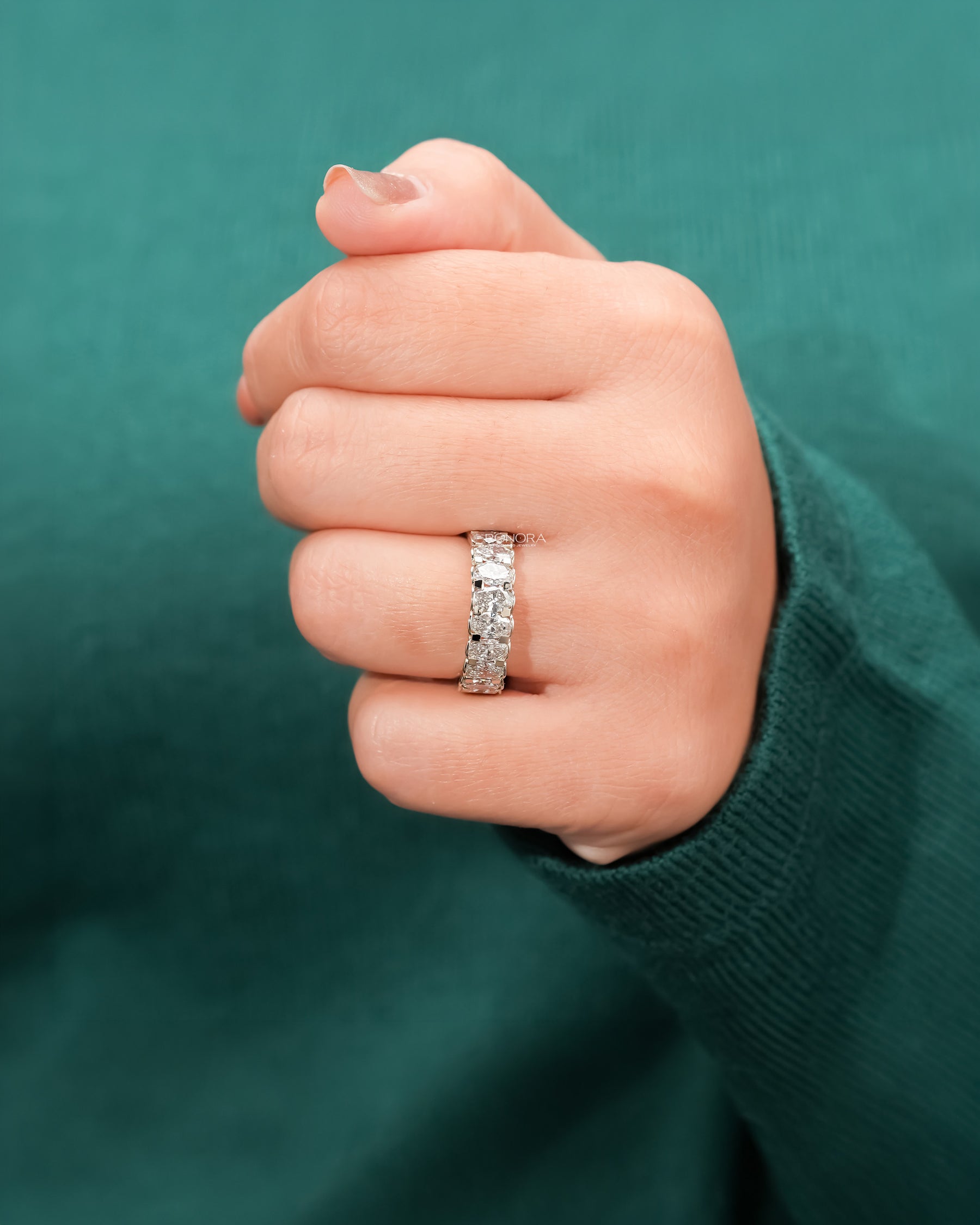 oval lab grown diamond eternity band worn on hand in white gold