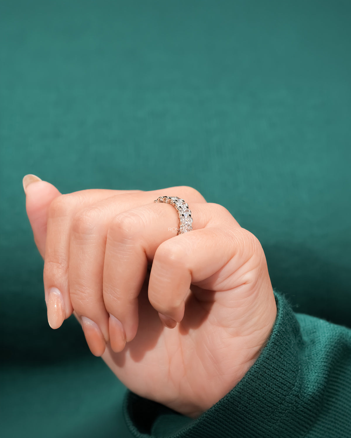 oval lab grown diamond eternity band worn with luxury styling in white gold