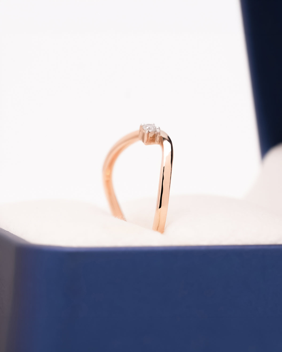 Angled view of rose gold solitaire ring with small round lab grown diamond