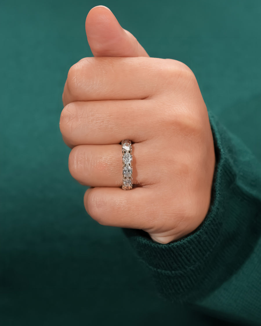 oval lab grown diamond eternity band worn on hand in yellow gold