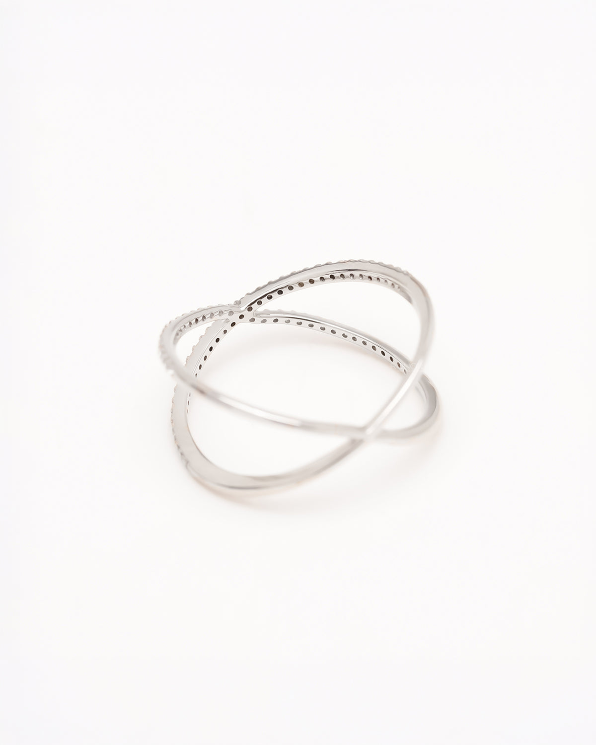 Angled view of white metal crossover ring with round pavé lab grown diamonds