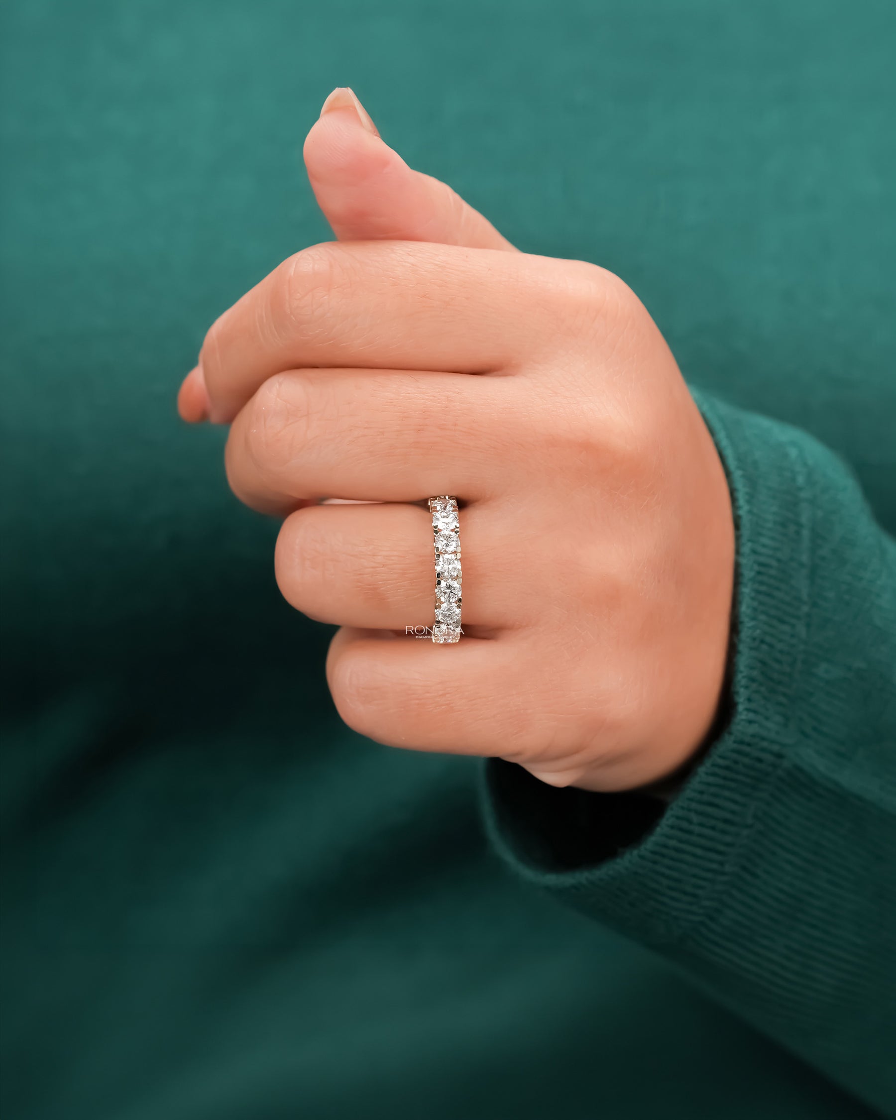 round lab grown diamond eternity band worn on hand in white gold