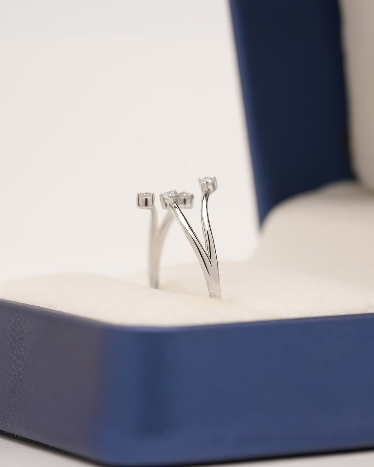 Side view of open bypass lab grown diamond ring standing in Ronora box