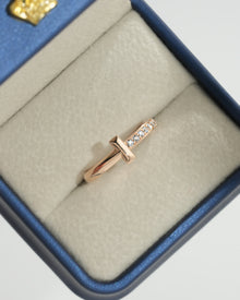 Top view of a rose gold flat bar lab grown diamond ring with pave stacking band in a navy and cream ring box