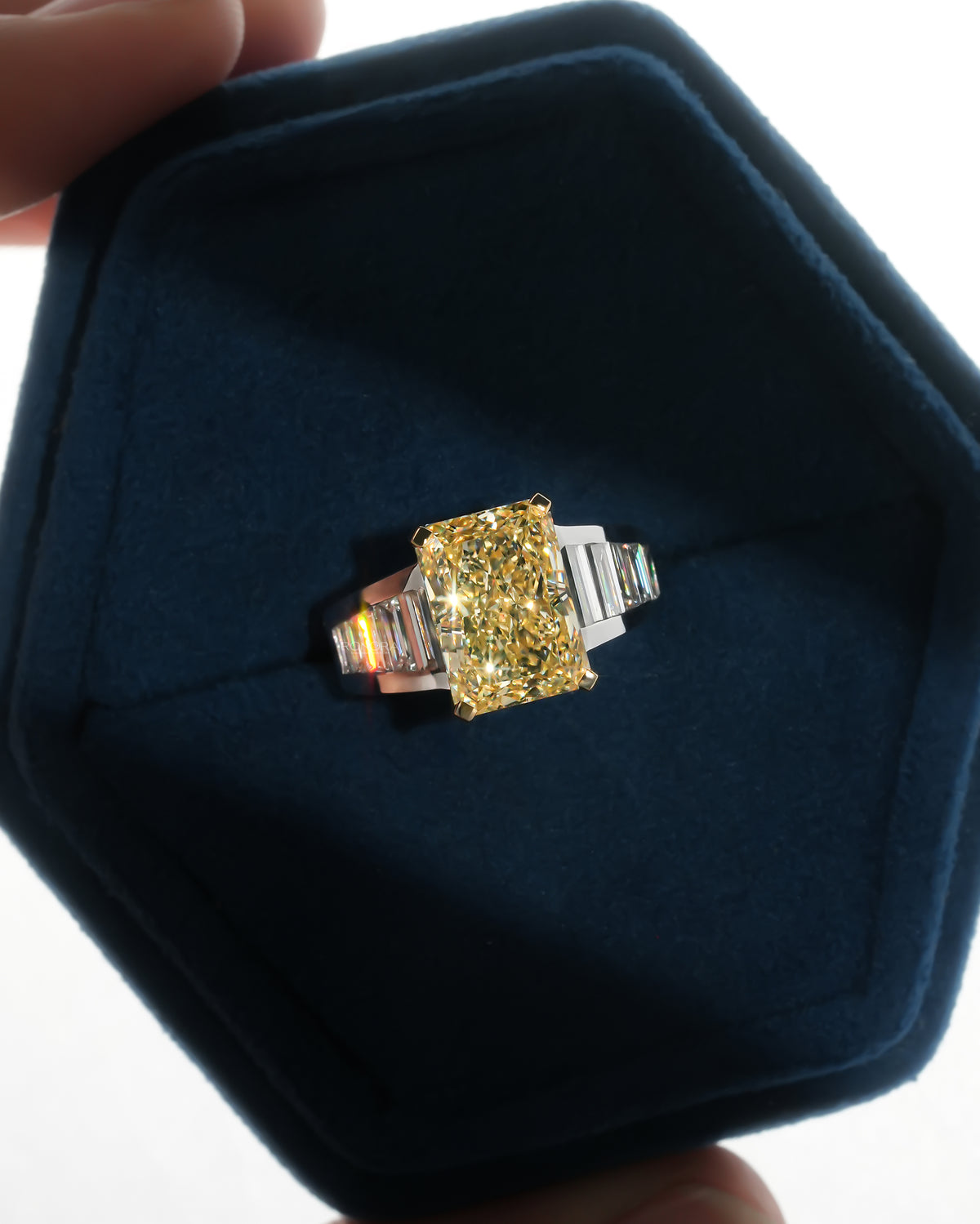 Fancy yellow radiant lab grown diamond ring with rows of baguette diamonds on each shoulder in a blue Ronora box