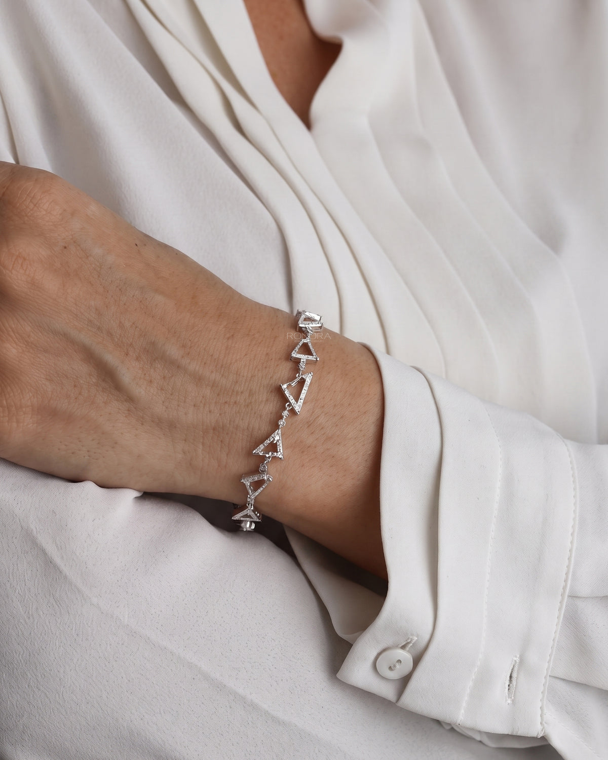 Model wearing the multi shape lab grown diamond bracelet with a cream blouse