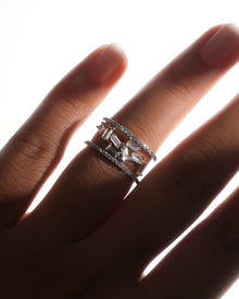 Hand wearing a baguette lab grown diamond cluster ring with scattered baguette stones between two pave rows