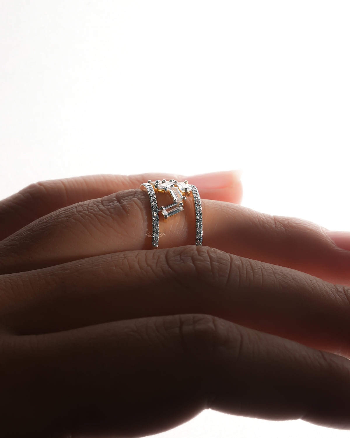 Side profile of a baguette lab grown diamond cluster ring worn on a finger, two pave rows with scattered baguettes