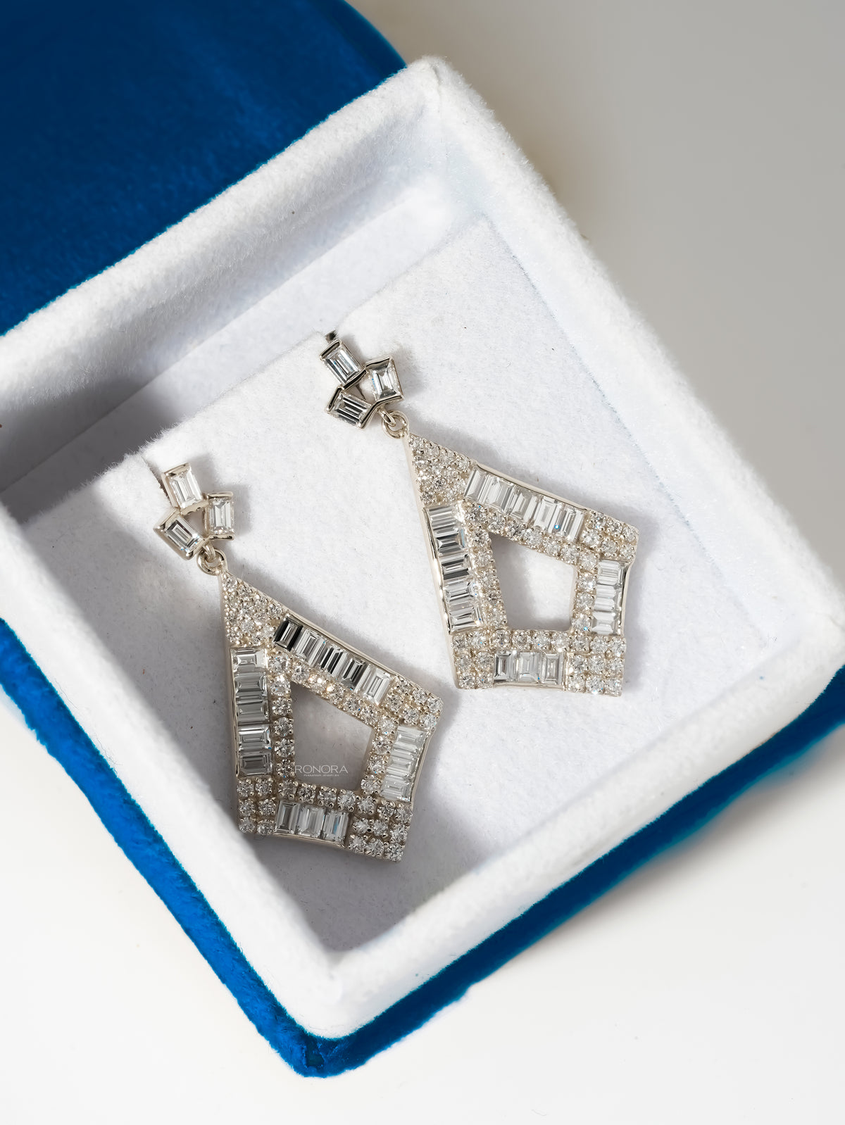 Baguette lab grown diamond drop earrings in a kite shape, white gold, resting in a white velvet jewelry box