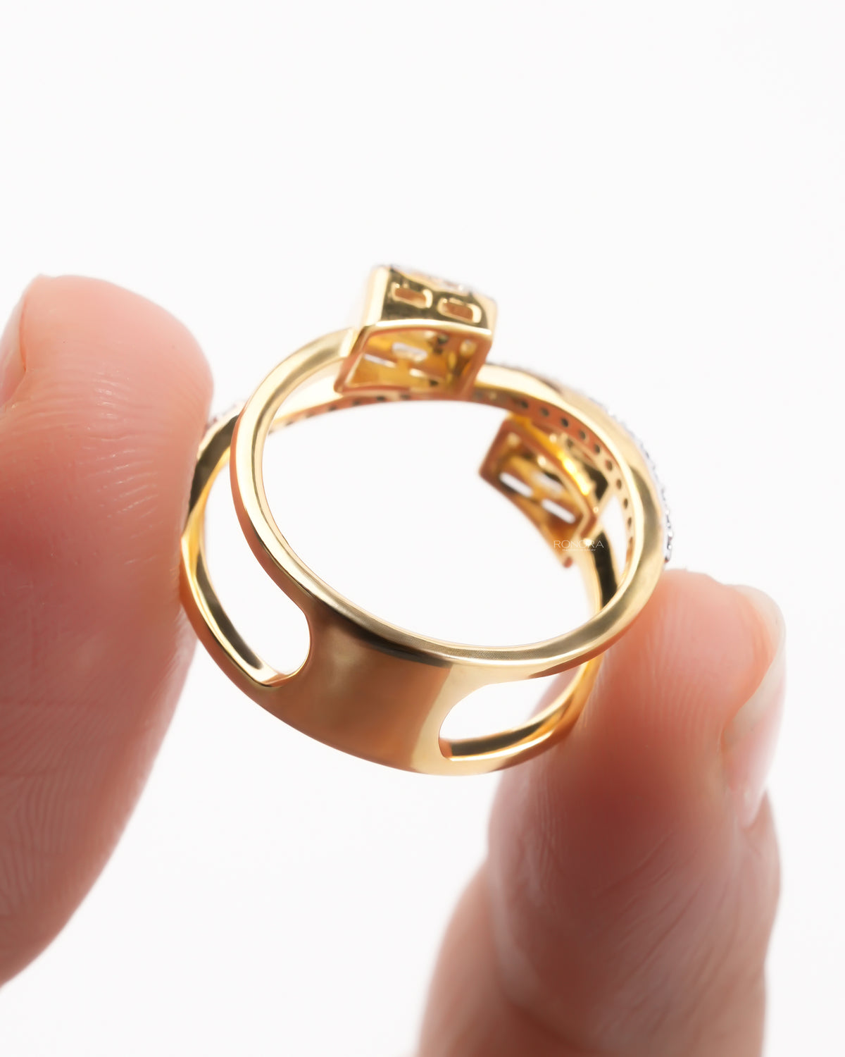 Back view of a yellow gold baguette lab grown diamond toi et moi ring showing the open cutout band design