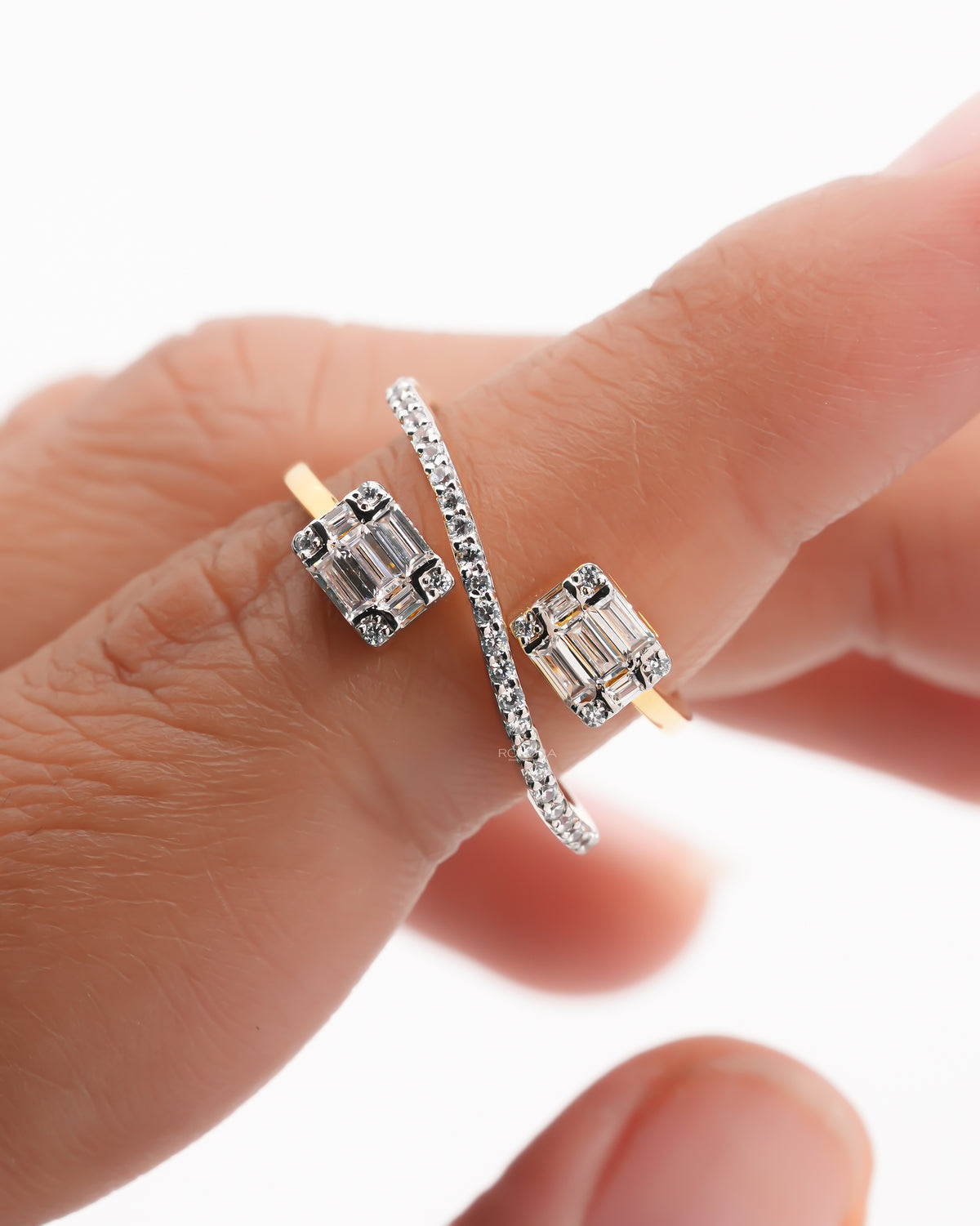 Close-up of a baguette lab grown diamond toi et moi ring on a finger, two baguette clusters and a pave bar