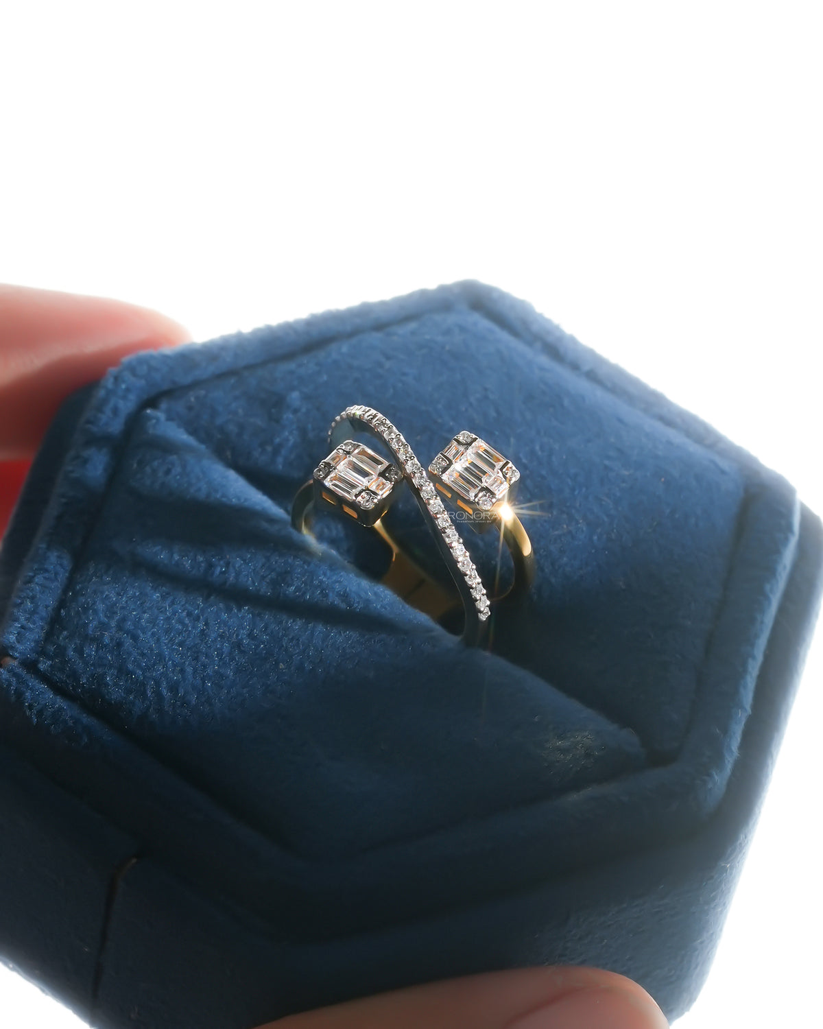 Baguette lab grown diamond toi et moi ring with a yellow gold band sparkling in a blue velvet jewelry box