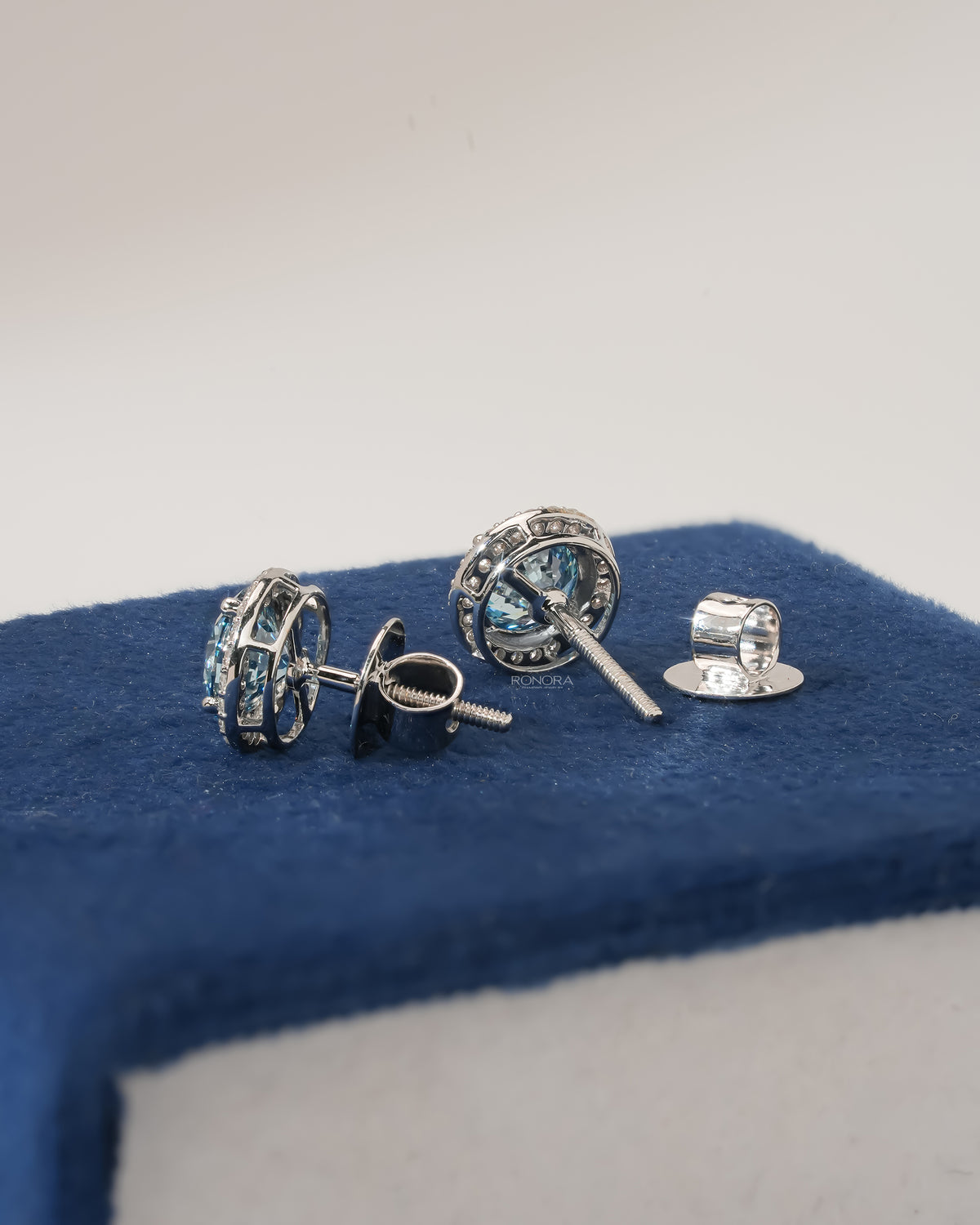 Back view of blue lab grown diamond halo stud earrings in white gold showing screw back posts and fittings