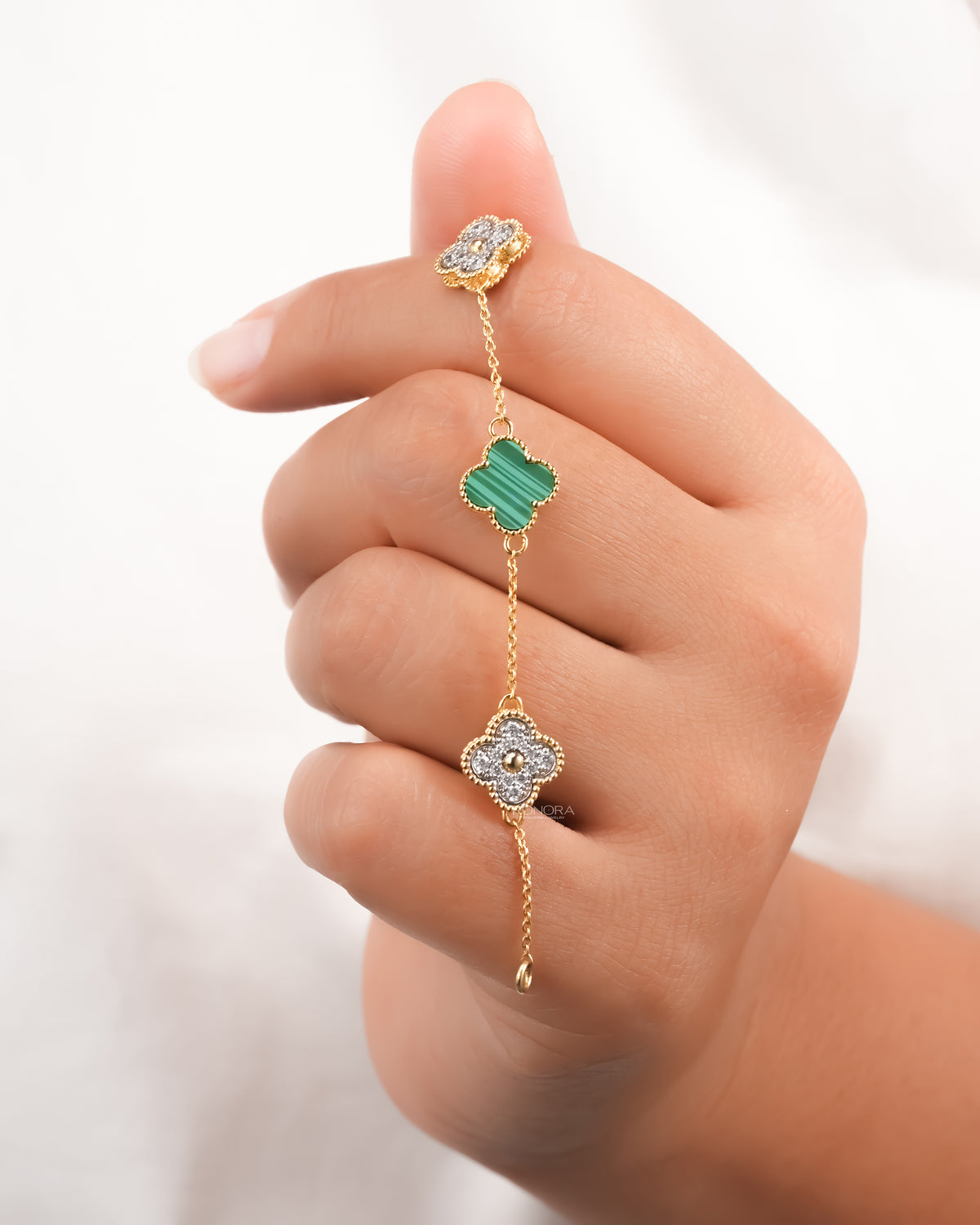 Clover malachite bracelet held in the hand showing the green malachite inlay