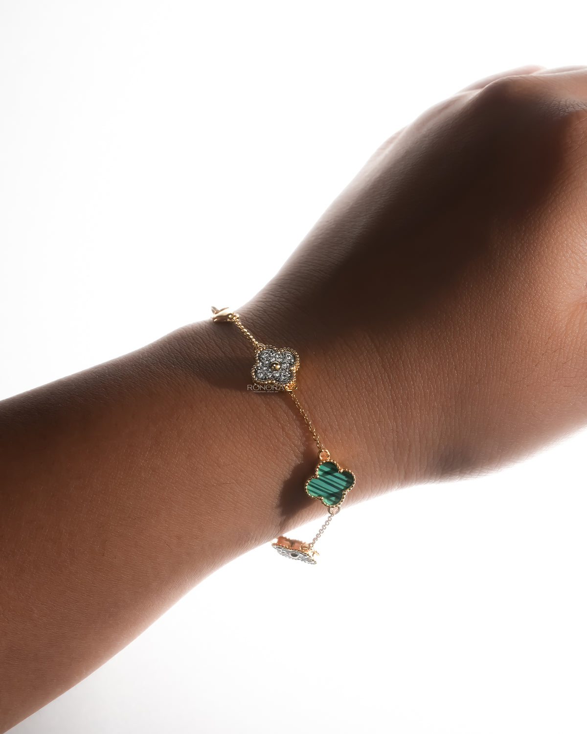 Clover malachite bracelet worn on the wrist against a light background