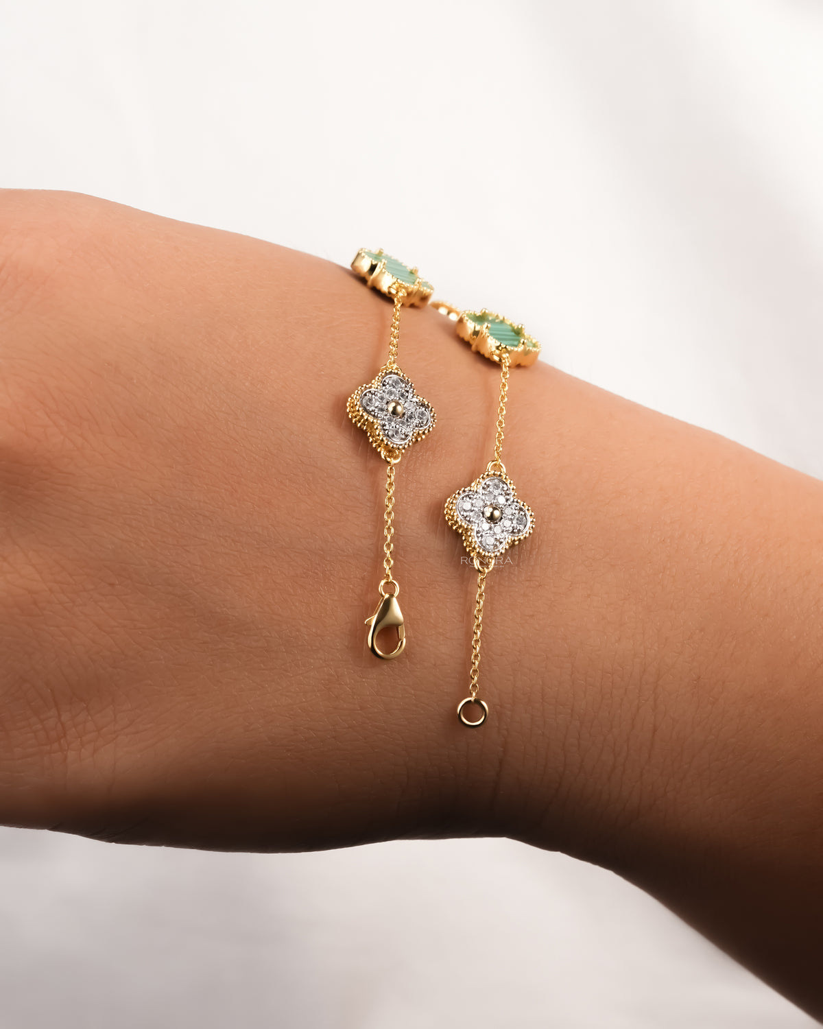 Clover malachite bracelet draped across the wrist in yellow gold