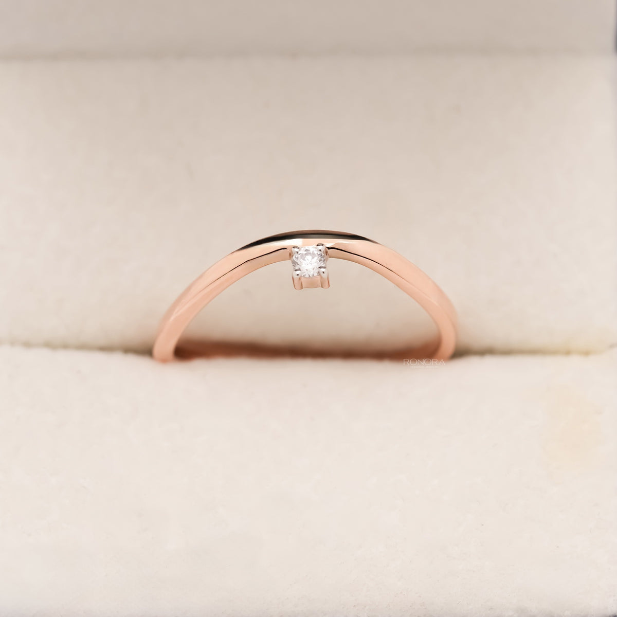 Dainty round lab grown diamond solitaire ring in rose gold with a small round stone on a gently curved band, front view