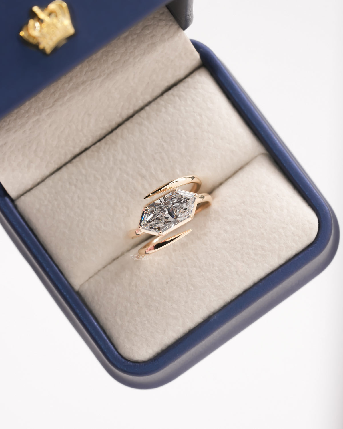 Dutch marquise lab grown diamond ring in rose gold in a blue ring box, top view of the east west bezel setting