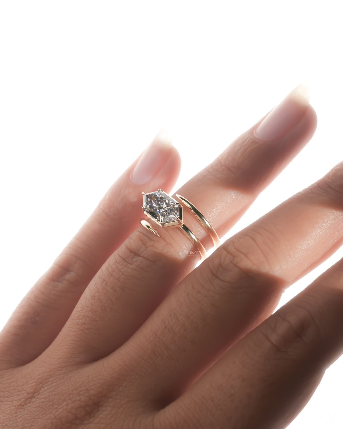 Dutch marquise lab grown diamond ring in rose gold on a finger, angled view of the bezel setting and bypass band