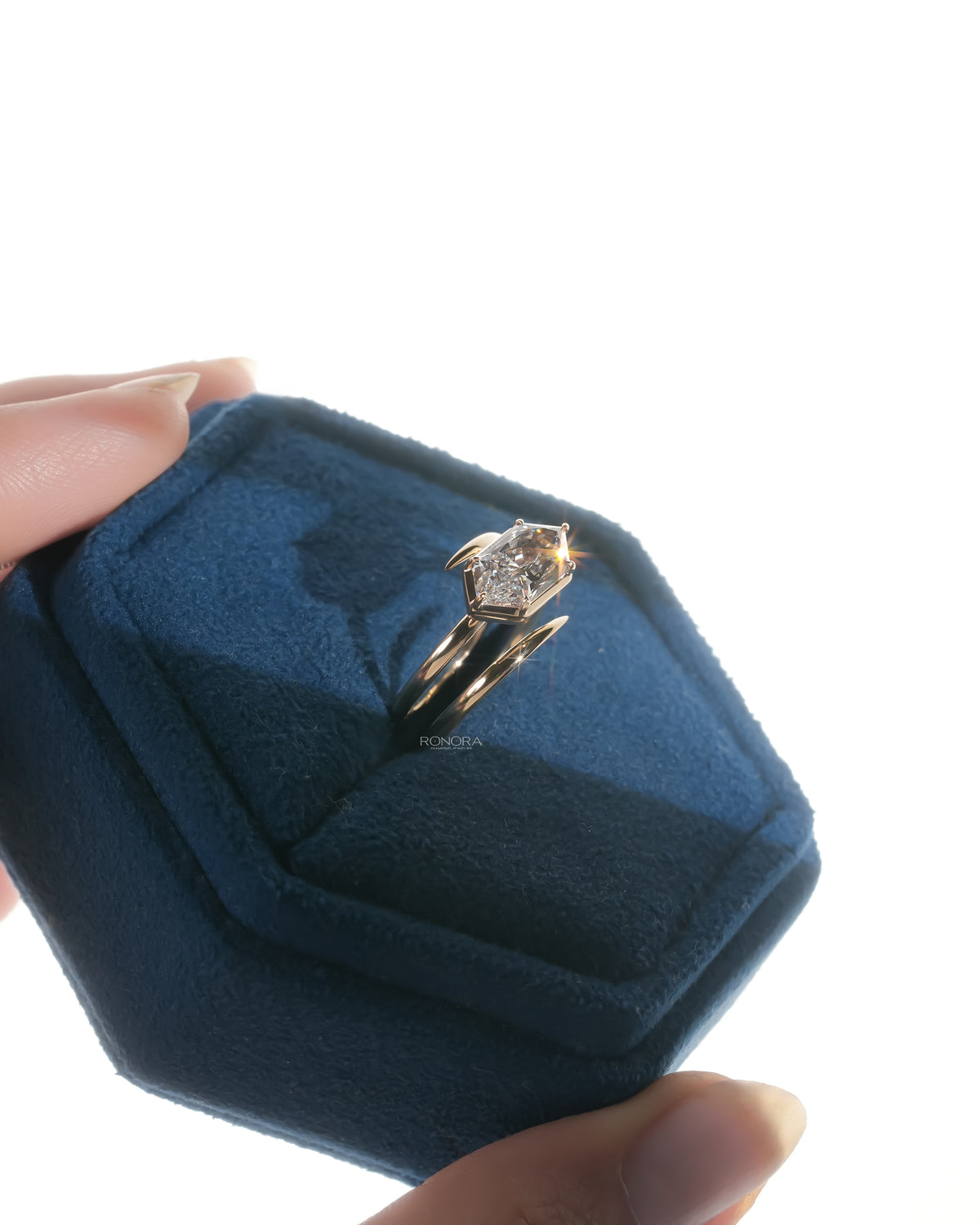 Dutch marquise lab grown diamond ring in rose gold in a blue velvet ring box, angled view with bypass band