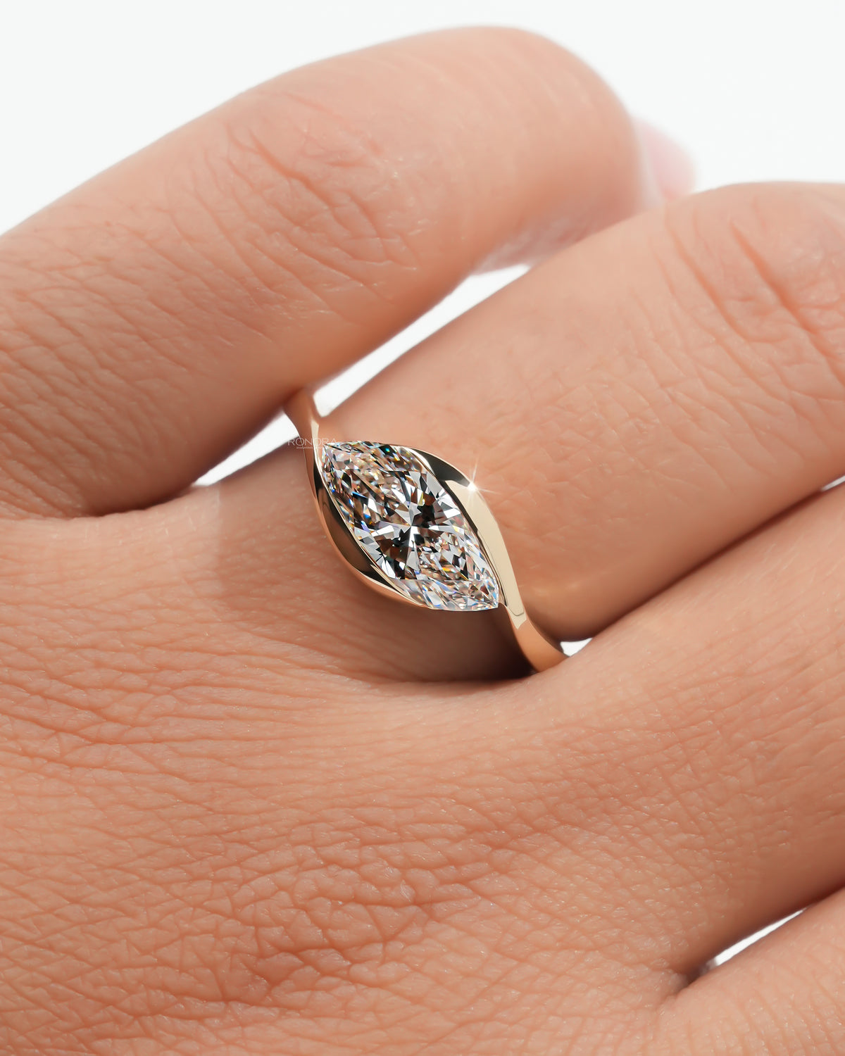 Marquise bezel lab grown diamond ring worn on the hand from above