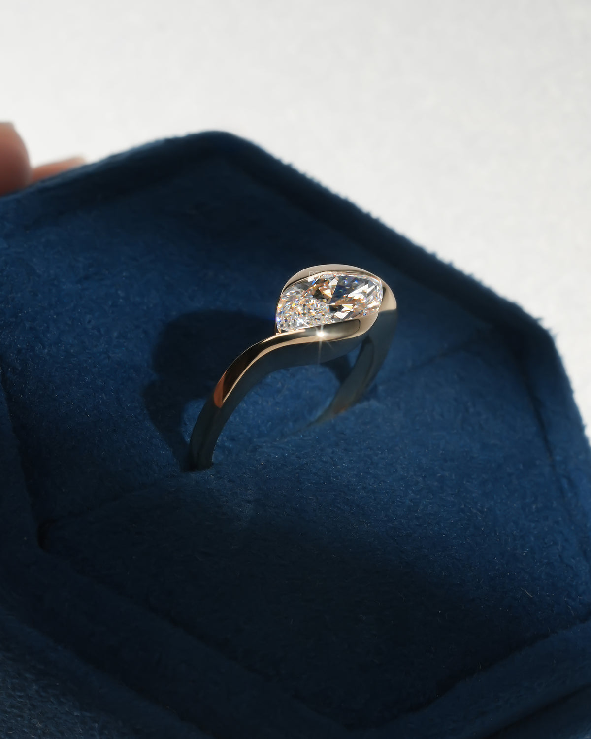 Marquise bezel lab grown diamond ring front view in a blue Ronora box