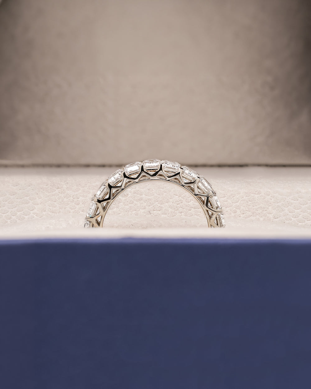 Side profile of emerald cut lab grown diamond eternity band showing ring setting