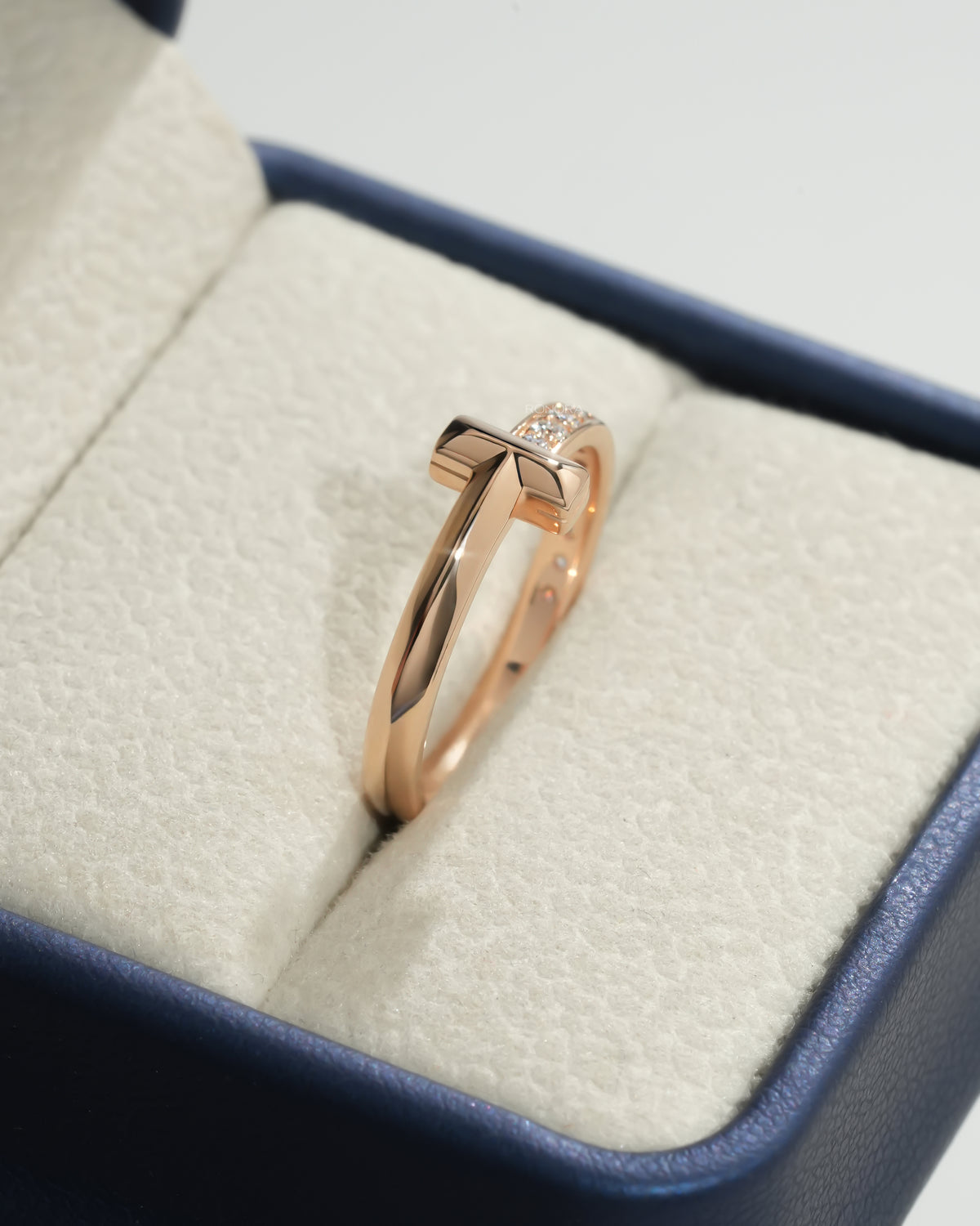 Rose gold flat bar lab grown diamond ring with pave stacking band standing in a navy and cream ring box