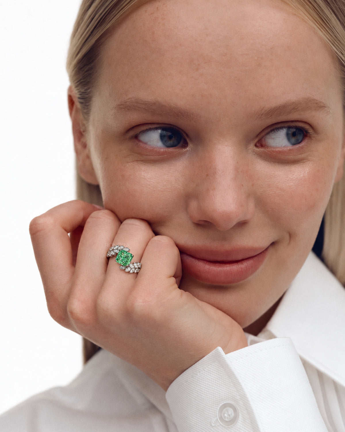 Model with her hand at her cheek wearing a green cushion lab grown diamond engagement ring with leaf sprigs