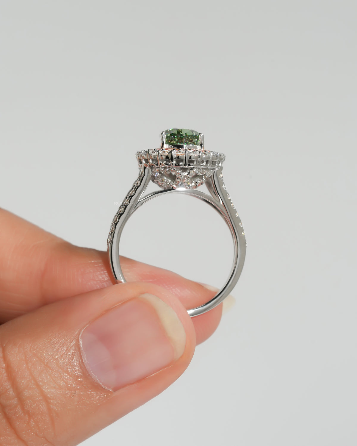 Side profile of a pear green lab grown diamond ring with pink double halo, showing the hidden under-halo detail