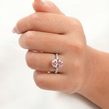 pink oval lab grown diamond halo ring worn on hand in white gold