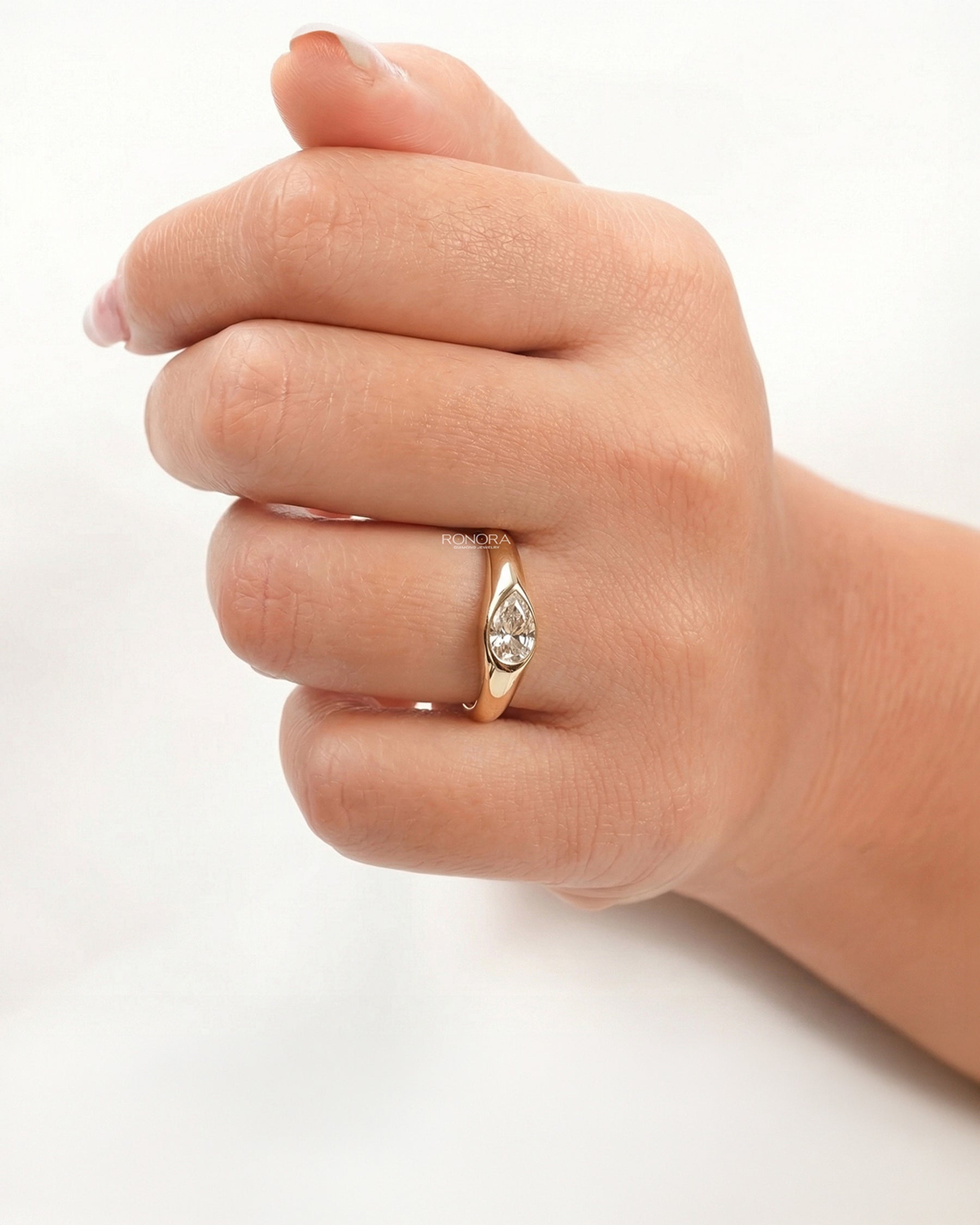 Close-up view of pear lab grown diamond bezel ring showing bezel setting