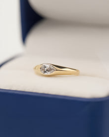 pear lab grown diamond bezel ring worn on hand in yellow gold